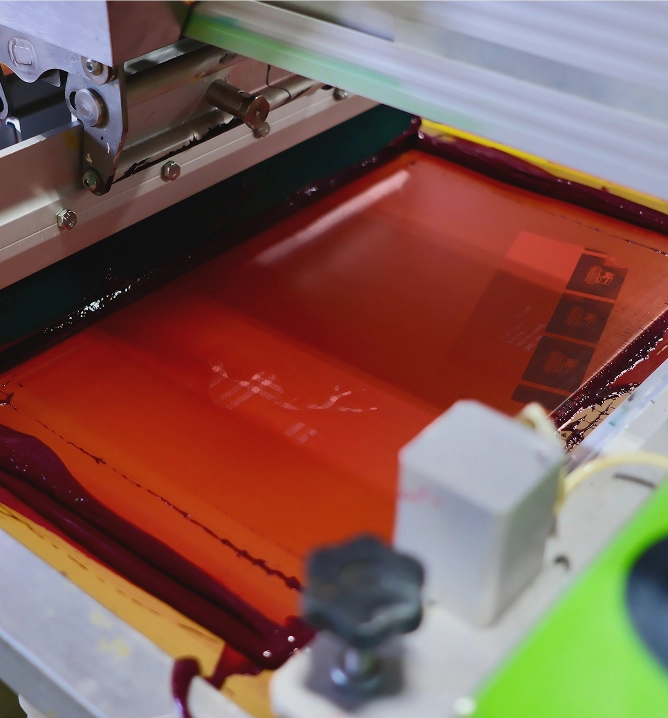 Screen printing press with red ink loaded on screen